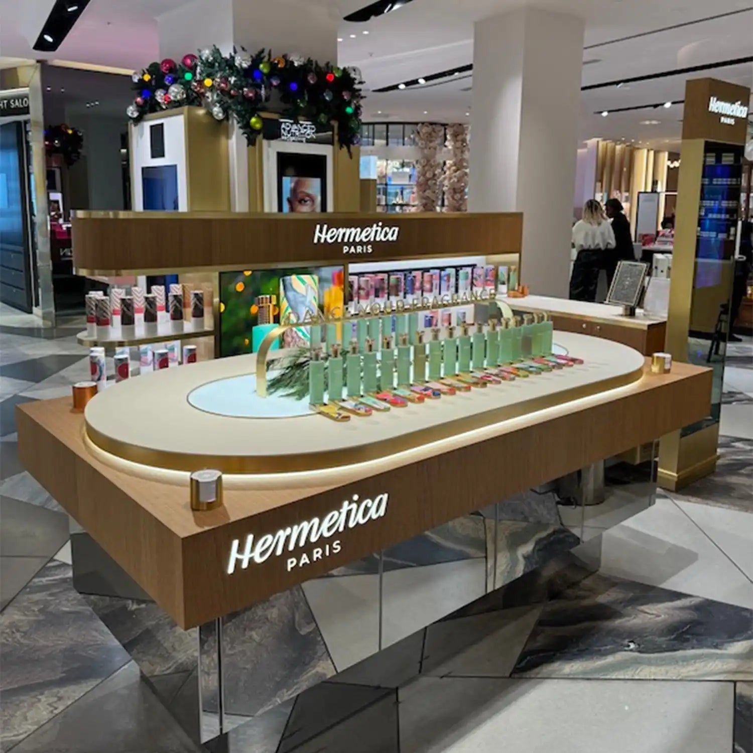 Hermetica perfume display counter with bottles arranged in an oval shape.