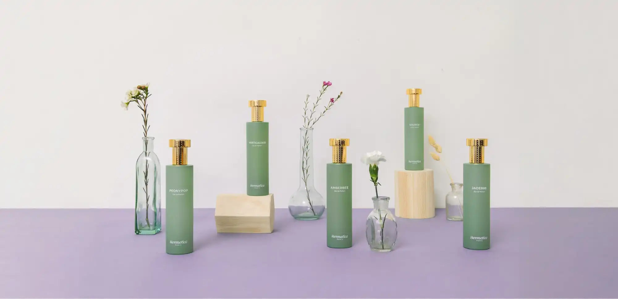 Mint green bottles and cream-colored blocks arranged with delicate stems in glass vases.