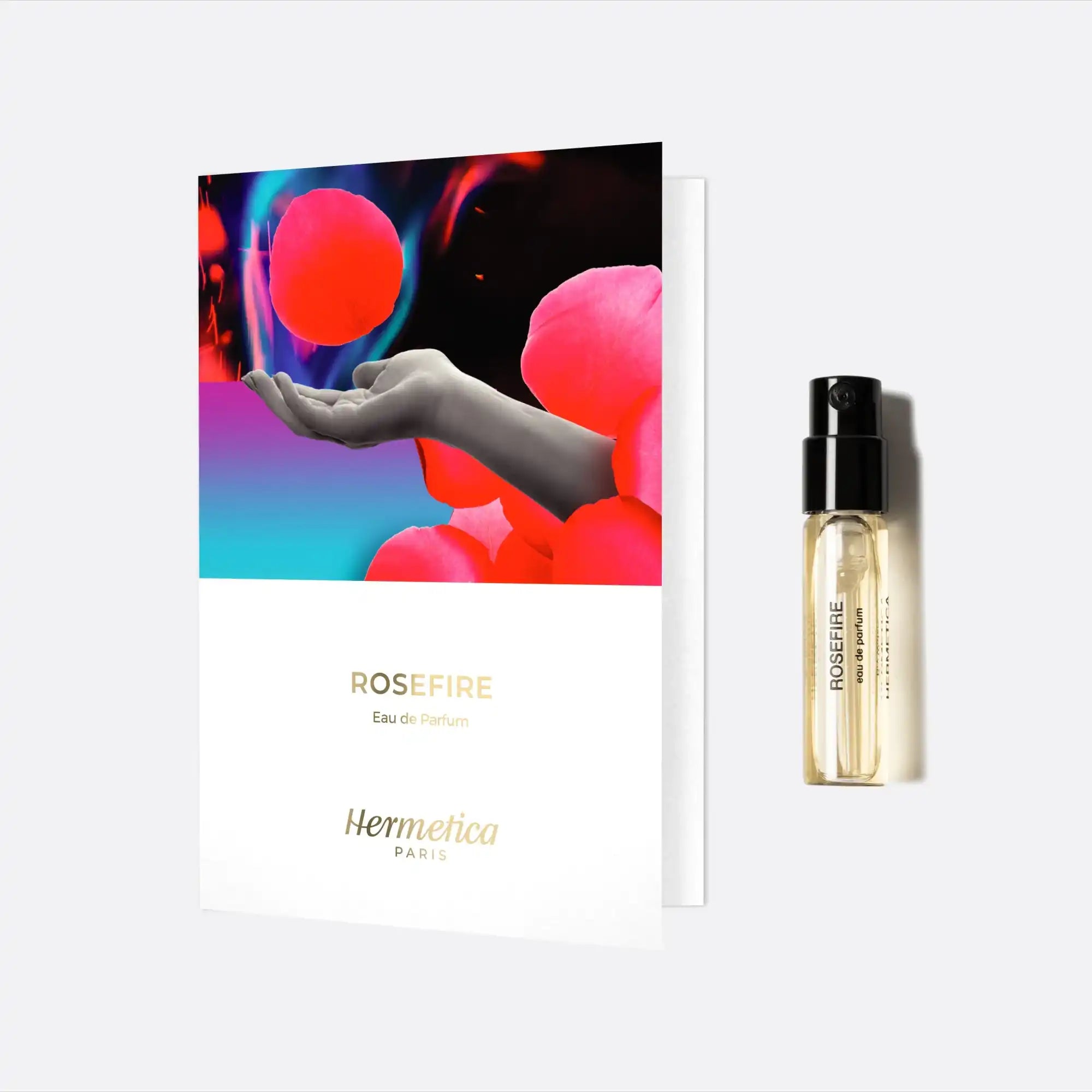 Perfume sample card with an artistic design featuring a hand and red spheres, accompanied by a fragrance vial.