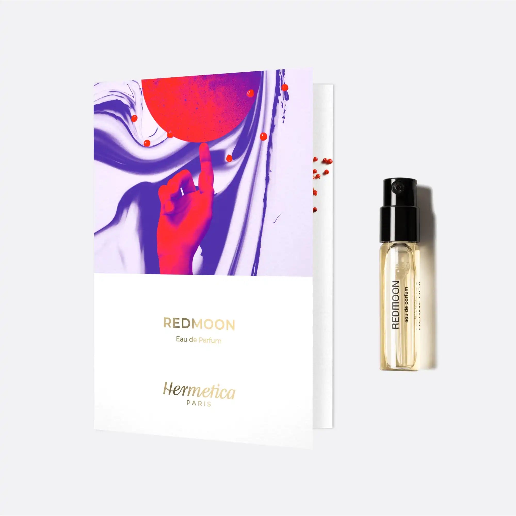 Perfume sample vial with accompanying artistic card featuring red and purple swirls.