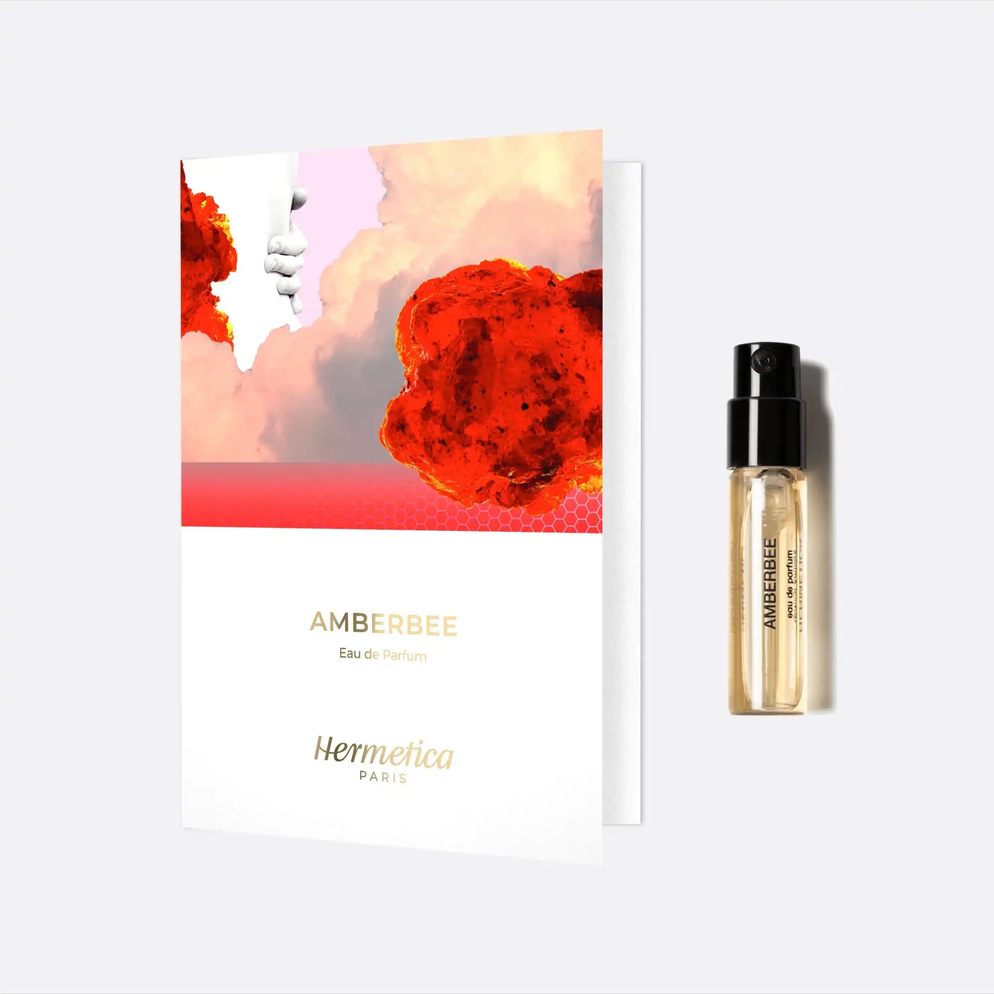 Perfume sample vial with a white and red artistic card.